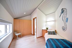 a guest room with a bed and a window at Casa da Baía - Guest House in Horta