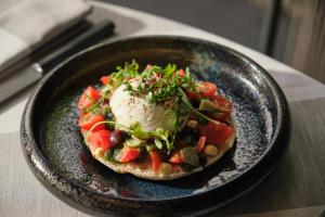 a plate with a pizza with an egg on it at Sant Francesc Hotel Singular in Palma de Mallorca