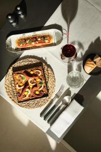 a table with a plate of pizza and a glass of wine at Sant Francesc Hotel Singular in Palma de Mallorca