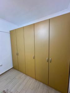 een kamer met bruine kasten en een houten vloer bij City Rest Apartment in Oradea