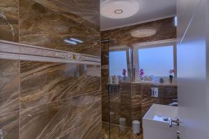 a bathroom with a sink and a glass shower at Appartement Ellara Penthouse in Žrnovo +38 photos