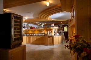 a large kitchen with wooden cabinets and a large island at Hotel Tirol- Natural Idyll in Montesover
