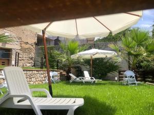 Massascusaにあるvilla ascosa residenceの草の中の一団の椅子と傘