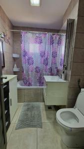 a bathroom with a toilet and a shower curtain at MMT SweetHome Sud in Ploieşti