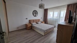 a bedroom with a bed and a clock on the wall at MMT SweetHome Sud in Ploieşti