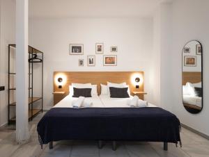 a bedroom with a large bed and a large mirror at La Central Sevilla in Seville +33 photos