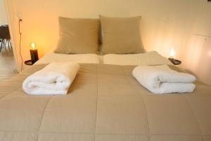 a large bed with two white towels on it at Best Stay Copenhagen Apartment 1550 in Copenhagen