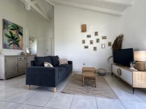 Una sala de estar con un sofá azul y un televisor. en CARIBEENNES Villa TiZoun, en Saint-François