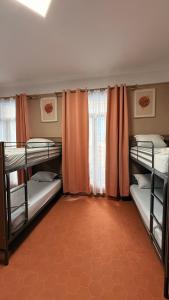 a room with four bunk beds with orange curtains at HOTEL SYLVABELLE in Marseille +24 photos