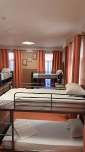 two beds in a room with orange curtains at HOTEL SYLVABELLE in Marseille