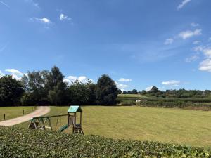 a park with a playground in a grass field at Portbridge Nest in Chew Magna