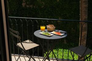 a table with a plate of food and a glass of orange juice at Sant Francesc Hotel Singular in Palma de Mallorca