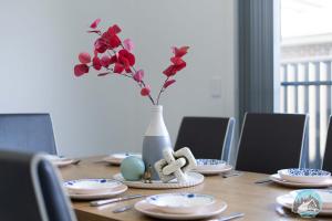 CobbittyAircabin - Cobbitty Spacious 4BR with 2 Baths的一张桌子,上面有花瓶,上面有红花 更多16张照片