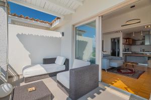 Una sala de estar con un sofá y sillas en un balcón. en Villa Artemis, en Quartu Sant'Elena 31 fotos más