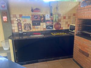 a kitchen with a black counter and tiles on the wall at Alvorecer do Pepê in Lagoa Santa +13 photos