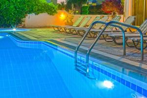 a swimming pool with lounge chairs and a swimming pool at Pavlos Hotel in Kos Town