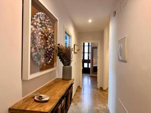 a hallway with a table and a painting on the wall at inncadiz El Refugio de Gadir in Cádiz