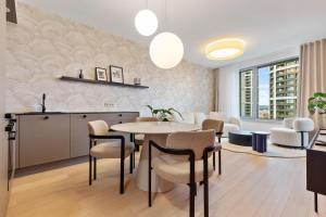 une cuisine et une salle à manger avec une table et des chaises dans l'établissement SkyPark Apartment with City Views Free Parking, à Nivy 17 autres photos