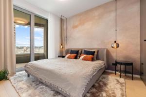 une chambre avec un grand lit et une grande fenêtre dans l'établissement SkyPark Apartment with City Views Free Parking, à Nivy