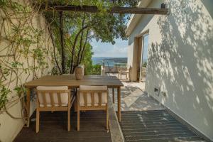 Una mesa y sillas de madera en un patio con vista. en Villa Artemis, en Quartu Sant'Elena