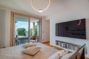 1 dormitorio con 1 cama y TV grande en la pared en Villa Artemis, en Quartu Sant'Elena
