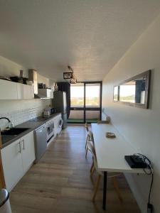 eine Küche mit Tisch und Stühlen in einem Zimmer in der Unterkunft Appartement spacieux et lumineux, idéalement situé in Pessac