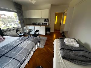a bedroom with a bed and a table and a kitchen at Brabo2 in Landskrona