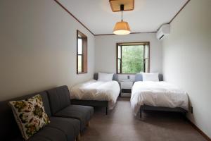 信浓Guesthouse SÁPMI的带沙发和两张床的客厅