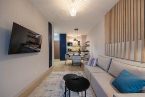 a living room with a couch and a table at Apartamenty Baltic Waves - visitopl in Międzyzdroje
