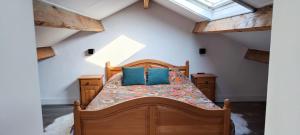 a bedroom with a wooden bed with blue pillows at Vacation on the farm in Lanaken