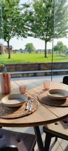 a wooden table with plates and utensils on it at Vacation on the farm in Lanaken
