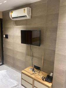 a room with a wall with a tv on a wall at Hotel Village Villa in Indore