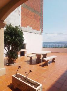 a picnic table and two benches on a patio at Casa do Castillo in Fisterra +12 photos