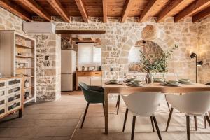 a kitchen with a wooden table and chairs at Geracasa Stone Villa in Méson Yerakaríon