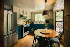 a kitchen with blue cabinets and a table with chairs at Riverstone Cottage A Cozy Riverfront Retreat in Dahlonega