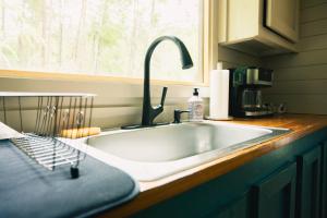 a kitchen counter with a sink and a window at Riverstone Cottage A Cozy Riverfront Retreat in Dahlonega +15 photos