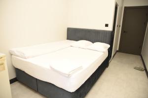 a bed with white sheets and pillows in a room at Çalışkan Otel in Havza