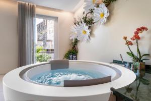 a bathtub in a room with flowers on the wall at Syrmioncello - Castle Lounge in Sirmione +26 photos
