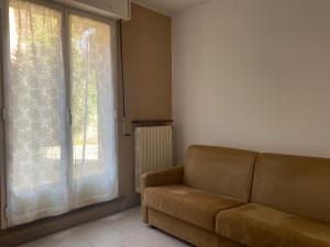 a living room with a couch and a large window at Appartamento Castiglioni in Grandate