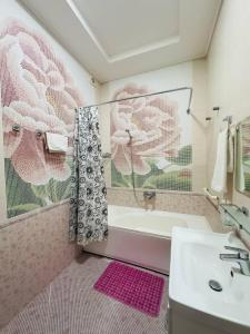 a bathroom with a sink and a shower curtain with flowers at Garden Boutique Hotel in Bukhara +43 photos