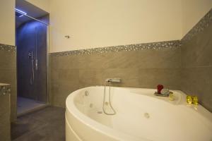 uma banheira branca na casa de banho com um chuveiro em B&B Villa Anna em Lucca