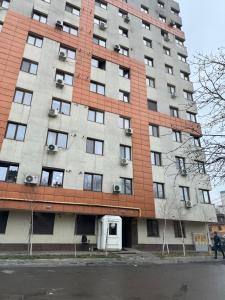 a tall apartment building with a person walking in front of it at Spacious 2 Bedroom Apartment in Iaşi