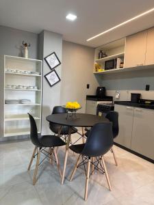 a dining room with a table and chairs in a kitchen at Charmoso apartamento no Centro de Patos PB in Patos