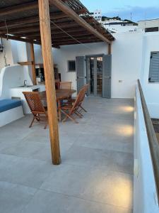 a patio with a wooden table and chairs at La Casa Bianca Naxos in Vívlos +33 photos