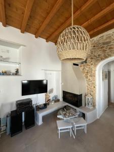 a living room with a fireplace and a chandelier at La Casa Bianca Naxos in Vívlos