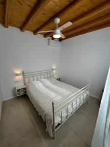 a bedroom with a bed and a ceiling fan at La Casa Bianca Naxos in Vívlos