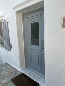 a gray door on a white wall with a window at La Casa Bianca Naxos in Vívlos