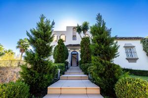 a house with trees in front of it at Stunning 5 Bedroom Villa in Puerto Banus with Pool in Marbella