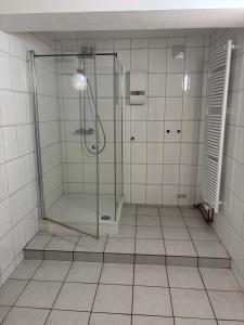 a bathroom with a shower with a glass door at Vastus homes in Duisburg