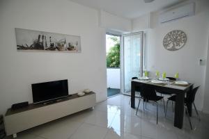 ein Wohnzimmer mit einem Esstisch und einem TV in der Unterkunft Casa Solari Rapallo in Rapallo
